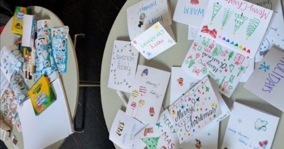 Two students with the holiday cards they wrote for families at St. Christopher’s Hospital for Children
